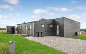 una pequeña casa negra con una entrada de grava en 4 Bedroom Gorgeous Home In Lgstrup en Løgstrup