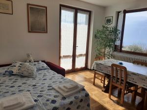 1 dormitorio con 1 cama, mesa y sillas en L'ulivo Apartment immerso nella tranquillità, en Lierna