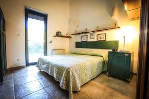 um quarto com uma cama e uma grande janela em Villa con parco e piscina em San Michele Salentino