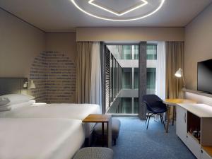 a hotel room with a bed and a desk and a window at Hyatt Place Zurich Airport the Circle in Kloten