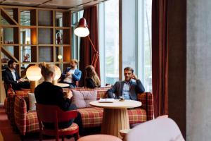 eine Gruppe von Menschen, die in einem Restaurant an einem Tisch sitzen in der Unterkunft Hyatt Place Zurich Airport the Circle in Kloten