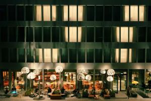 a lobby of a building with people sitting in chairs at Hyatt Place Zurich Airport the Circle in Kloten