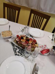 einen weißen Tisch mit einem Teller Essen drauf. in der Unterkunft Barátság Panzió - Pensiunea Barátság in Ditrău