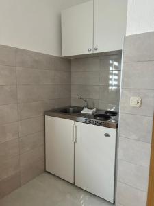 a small kitchen with a sink and a stove at ADRIA in Podaca