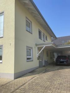 a house with a car parked in front of it at Melli‘s Seenahe Ferienwohnung in Langenargen