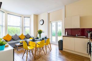 cocina y sala de estar con mesa y sillas amarillas en Greyfriars en Clacton-on-Sea