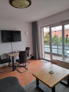 sala de estar con sofá, mesa y ventana en Apartment Wiesener, en Büsum