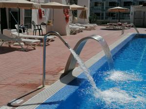 uma piscina com água a sair dela em Apartamento Glamour near Yumbo Center em Playa del Inglés