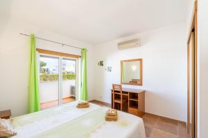 a bedroom with a bed and a desk and a mirror at Recanto da Galé by Umbral in Albufeira