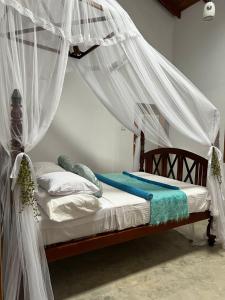 a bedroom with a canopy bed with white mosquito nets at Angelica Villa in Bentota