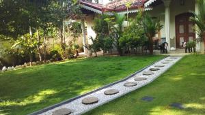 a garden with a stone path in front of a house at Angelica Villa in Bentota