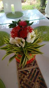 a vase filled with flowers on a table at Angelica Villa in Bentota