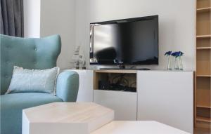 a living room with a tv and a blue chair at Residentie Placide in Ostend