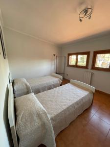 Zimmer mit 3 Betten und weißer Bettwäsche in der Unterkunft Villa Marina in Torvaianica