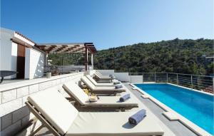 a patio with lounge chairs and a swimming pool at Beautiful Home In Kalebova Luka With Heated Swimming Pool in Ražanj