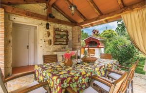 a table and chairs on a patio with a fireplace at Pet Friendly Home In Basici With Outdoor Swimming Pool in Bašići