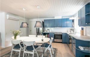 Spidsegårdにある3 Bedroom Cozy Home In Nexのキッチン(青いキャビネット、白いテーブルと椅子付)