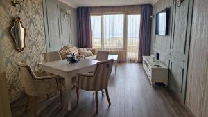 una sala de estar con una mesa y un sofá en FS Apartments - Modern Sea-View Apt - First Line, en Golden Sands