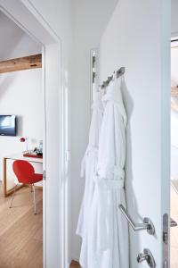 B&B Park7 Wavre - Leuven في Huldenberg: رداء أبيض معلق على باب في غرفة