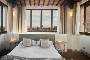 una camera da letto con un letto e una grande finestra di B&B Le Logge Luxury Rooms a Siena