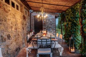 comedor con mesa, sillas y lámpara de araña en VILLA IL TINAIO Romantic Secluded Farmhouse with Private Pool, en Valgiano