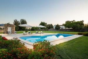 einen Pool im Garten mit Stühlen und Sonnenschirmen in der Unterkunft Honeymoon Leonor Villa in Lucca