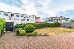 a brick courtyard with a building and a bench at Greyfriars in Clacton-on-Sea