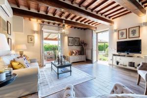 un salon avec un canapé et une télévision dans l'établissement VILLA PEMOLA a Luxury Farmhouse with Garden and bikes in Lucca Town, à Parezzana