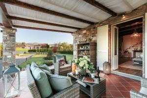 une terrasse avec un canapé et une table dans l'établissement VILLA PEMOLA a Luxury Farmhouse with Garden and bikes in Lucca Town, à Parezzana