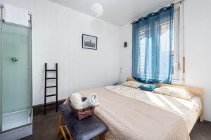 - une chambre avec un grand lit, une chaise et une fenêtre dans l'établissement Le saint honoré, à Amiens