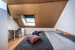 - une chambre avec un grand lit et un plafond en bois dans l'établissement Le saint honoré, à Amiens