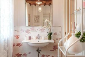 une salle de bain avec un lavabo et un miroir dans l'établissement VILLA PEMOLA a Luxury Farmhouse with Garden and bikes in Lucca Town, à Parezzana 53 autres photos