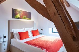 een slaapkamer met een bed met rode kussens bij B&B Park7 Wavre - Leuven in Huldenberg