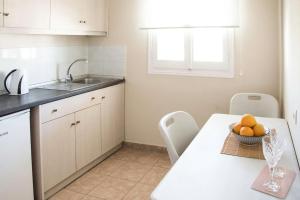 a kitchen with a table with a bowl of oranges on it at Margaret Apartments in Lefkimmi