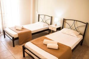 two beds in a room with two towels on them at Margaret Apartments in Lefkimmi