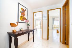 a hallway with a table and a painting on the wall at Apartamento Sra da Rocha by Umbral in Porches