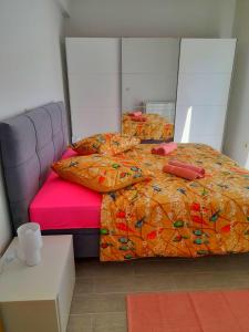 a bedroom with two beds with orange comforter at House Forest&Beach Relax in Rab