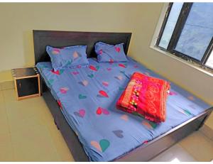 a bed with a blue comforter with hearts on it at Hotel Rudra and Restaurant, Gopeshwar in Gopeshwar