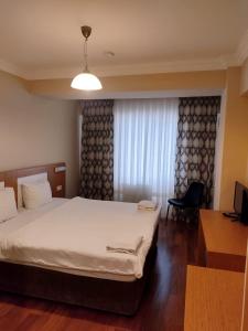 Habitación de hotel con cama y TV en MD CITY HOTEL, en Canakkale