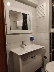 Baño blanco con lavabo y espejo en MD CITY HOTEL, en Canakkale