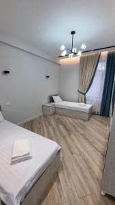 1 dormitorio con 2 camas y ventana grande en ANDL APARTMENTS en Samarcanda