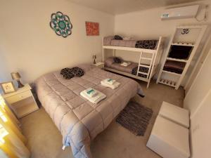 a small bedroom with a bed and bunk beds at Rincón del Alma in Saladillo