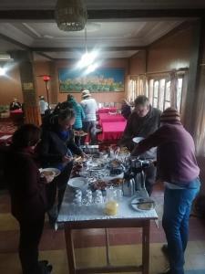 a group of people standing around a table with food at Hotel Awayou in Bou Tharar