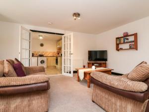 a living room with two couches and a tv at Priory House Cottage in Barnstaple