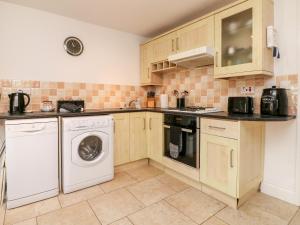 a kitchen with a washing machine and a washer at Priory House Cottage in Barnstaple +9 photos