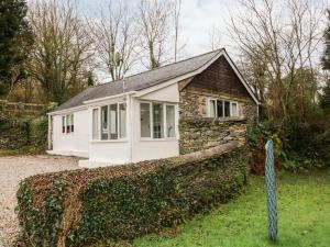 a small cottage with a stone wall at Priory House Cottage in Barnstaple