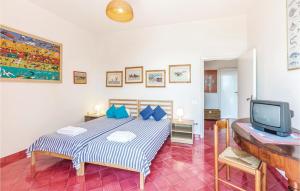 a bedroom with a bed with blue pillows and a tv at Casa Sorvillo in Vietri sul Mare