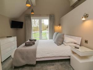 een slaapkamer met een bed, een wastafel en een raam bij Priory House in Barnstaple