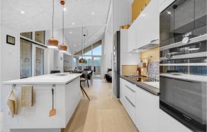 een keuken met witte kasten en een woonkamer bij 4 Bedroom Stunning Home In Sjlund in Sjølund