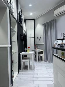 kuchnia z dwoma białymi stołami i półkami w obiekcie Parthenope Rooms w mieście Neapol